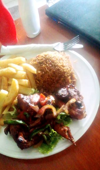 Chicken wings served with chips and Pilau